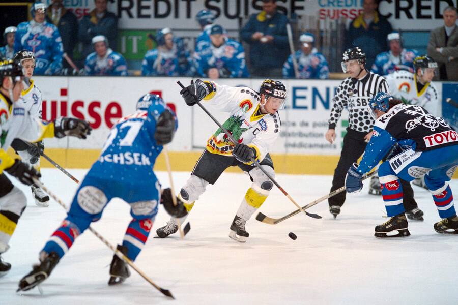 Mario Rottaris, Mitte, HC Fribourg-Gotteron, versucht sich im Meisterschaftsspiel der Nationalliga A gegen den Klotener Jiri Kucera, rechts, durchzusetzen, aufgenommen am 7. Maerz 1998 in Freiburg. (KEYSTONE/Fabrice Coffrini)